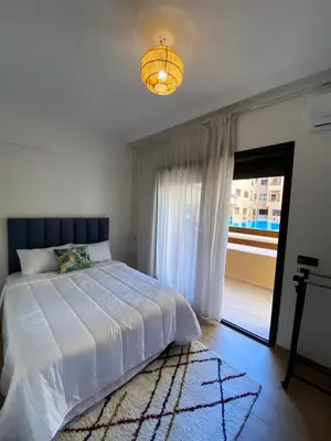a bedroom with a white bed and a window at Magnifique & élégant appartement in Marrakech