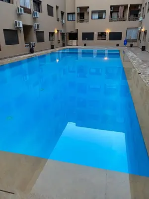 a large blue swimming pool in a building at Magnifique & élégant appartement in Marrakech