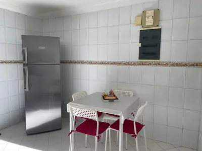 a kitchen with a table with chairs and a refrigerator at ☆HIVERNAGE☆ Charming , Spacious & Bright with Pool in Marrakech
