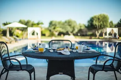a table with food on it next to a pool at L'Orientale By La Siredrah in Marrakech