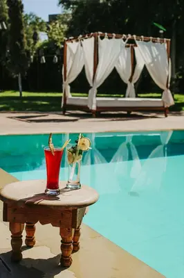 a table with two vases on it next to a pool at L'Orientale By La Siredrah in Marrakech