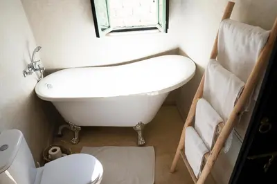 a bathroom with a tub and a sink and a toilet at Riad Chic in Marrakech