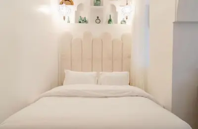 a white bed with white sheets and pillows at Riad Manzal in Marrakech