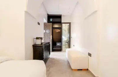 a bedroom with a white bed and a white couch at Riad Manzal in Marrakech