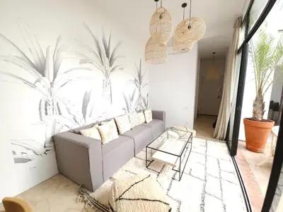 a living room with a couch and a mural of palm trees at Riad Coconut in Marrakech