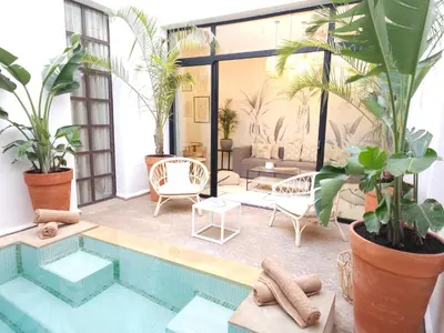 a patio with a swimming pool and plants at Riad Coconut in Marrakech