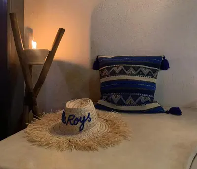 a hat on a table with a pillow and a candle at Riad Le Roy’s in Marrakech