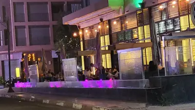 a group of people sitting outside of a building at night at hamza in Marrakech