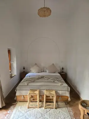 a bedroom with a bed in a white room at RIAD SAMAH in Marrakech