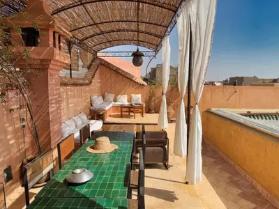 a patio with a table and chairs on a roof at Riad l'Echappée, en exclusivité, 5 chambres in Marrakech