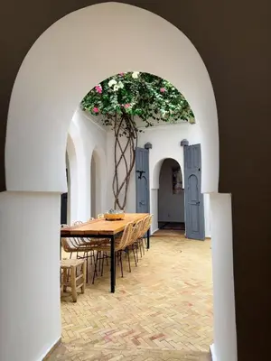 a dining room with a table with a flower arrangement at Riad l'Echappée, en exclusivité, 5 chambres in Marrakech