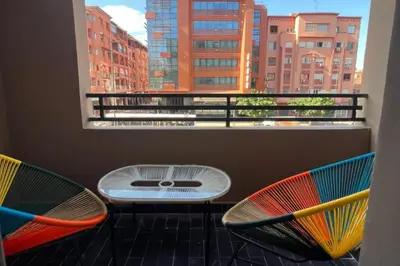 a balcony with two chairs and a table and a window at 1 Bed Apartment - Balcony Wifi Parking in Marrakech