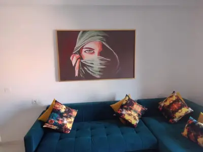a blue couch in a living room with a painting at 1 Bed Apartment - Balcony Wifi Parking in Marrakech