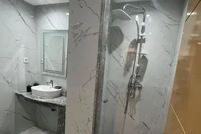 a white bathroom with a shower and a sink at 1Bed Apartment - Sleeps 4 - Balcony Parking Wifi in Marrakech