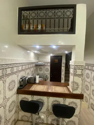 a bar with two black stools in front of it at MAISON PROCHE DANS LA MEDINA MARRAKECH in Marrakech