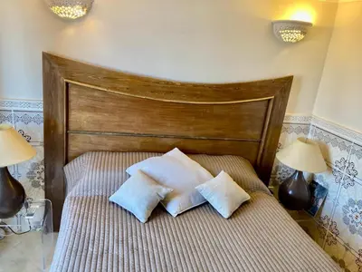 a bed with two pillows on it with two lamps at MAISON PROCHE DANS LA MEDINA MARRAKECH in Marrakech