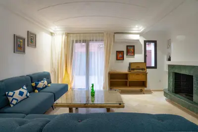 a living room with a blue couch and a fireplace at Aya Suites in Marrakech