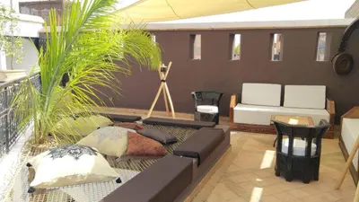 a living room with a couch and some plants at Ryad Petit Palmier in Marrakech