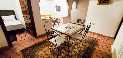 a table and chairs in a room with a bedroom at Riad 1954 in Marrakech