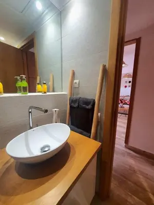 a bathroom with a white sink on a wooden counter at Bel appartement au centre gueliz in Marrakech