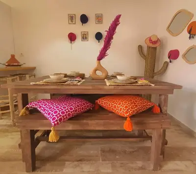 a wooden table with pillows on a wooden bench at Bel appartement au centre gueliz in Marrakech