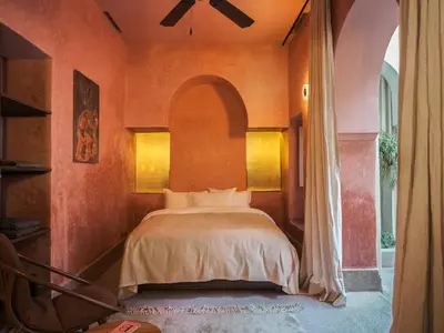 a bedroom with a bed with an arched window at Riad Brummell Medina in Marrakech