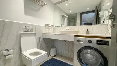 a bathroom with a washing machine and a sink at Duplex IKA - Appartement design à Marrakech in Marrakech
