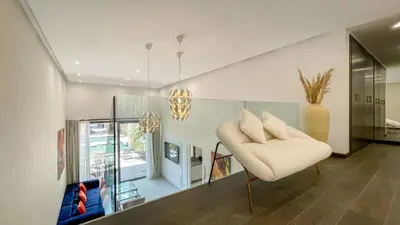 a living room with a chair and a vase at Duplex Zoé - Contemporain et design à Marrakech in Marrakech