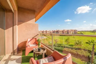 a balcony with two chairs and a table with a view at Luxury Apartments Prestigia Pools Golf Fiber Parking in Marrakech