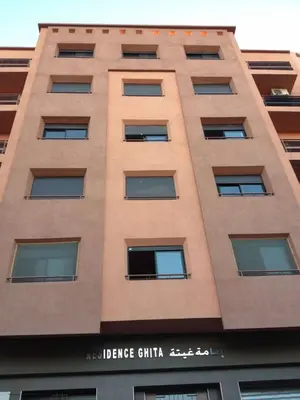 a tall tan building with the words justice clinic at Résidence Ghita La terrasse in Marrakech