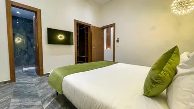 a bedroom with a large white bed with green pillows at Villa AZUR - piscine chauffée sans vis-à-vis à Marrakech in Marrakech