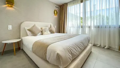 a bedroom with a large bed and a large window at Villa AZUR - piscine chauffée sans vis-à-vis à Marrakech in Marrakech