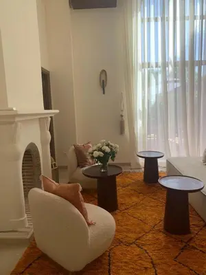 a living room with a couch and tables and a fireplace at Villa Magnolia - Amelkis Golf in Marrakech