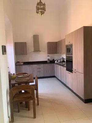 a kitchen with a table and chairs and a tableasteryasteryasteryasteryasteryastery at Villa Magnolia - Amelkis Golf in Marrakech