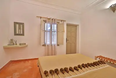 a bedroom with a large bed with a window at Riad Al Badia in Marrakech
