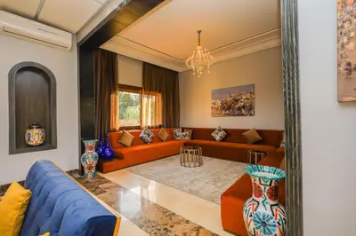a living room with orange furniture and a blue couch at Konouz Palace in Marrakech