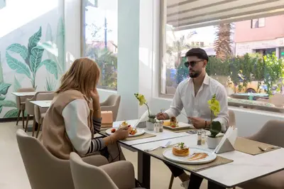 a man and a woman sitting at a table eating food at Tempoo Hotel Marrakech City Centre Adults Only in Marrakech