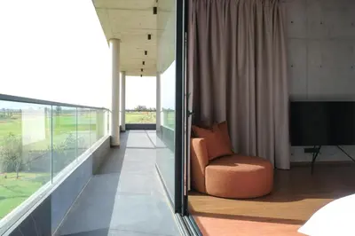 a room with a balcony with a chair and a television at VIP villa in Marrakech