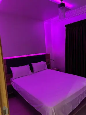 a bedroom with a bed with purple lights on it at Propre appartement à loué pour les familles in Marrakech