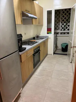 a kitchen with a refrigerator and a stove top oven at Propre appartement à loué pour les familles in Marrakech