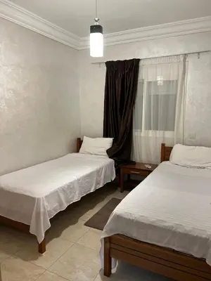 a room with two beds and a window at Propre appartement à loué pour les familles in Marrakech