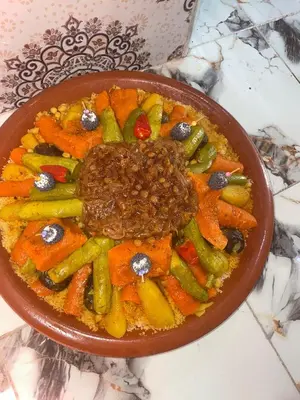a bowl of food with meat and vegetables on a table at Villa BALI KECH in Marrakech