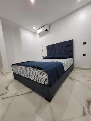 a bedroom with a bed in a white room at Magnifique appartement duplex à 5min de l'aéroport de Marrakech in Marrakech