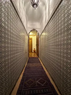 a hallway with a tile wall and a hallway with a rug at Dar Dadès in Marrakech