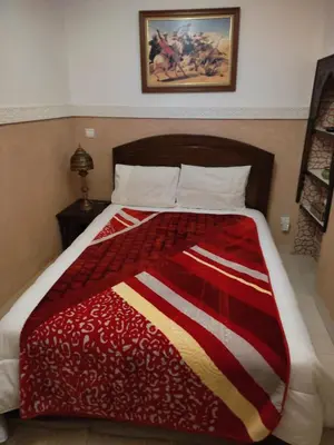 a bed with a red and white blanket on it at Dar Dadès in Marrakech