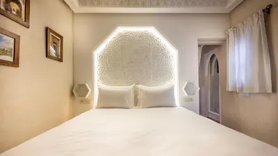 a bedroom with a bed with a white head board at Luxe Nomade Marrakech & Spa in Marrakech