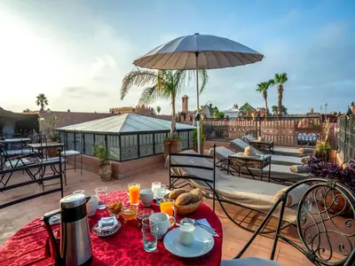a table with food and an umbrella on a patio at Riad Dar Nakhla in Marrakech