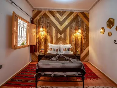 a bedroom with a bed and a wooden wall at Riad Dar Nakhla in Marrakech