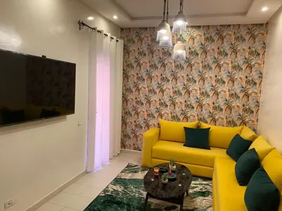 a living room with a yellow couch and a table at Studio Cosy au Centre de Marrakech - Guéliz - in Marrakech