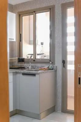 a kitchen with a sink and a window at Appart très élégant avec piscine in Marrakech
